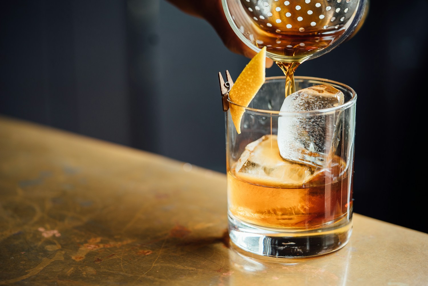 A crafted cocktail with a citrus garnish